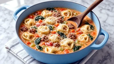 Creamy tortellini soup with Italian sausage, spinach, and carrots in a Dutch oven