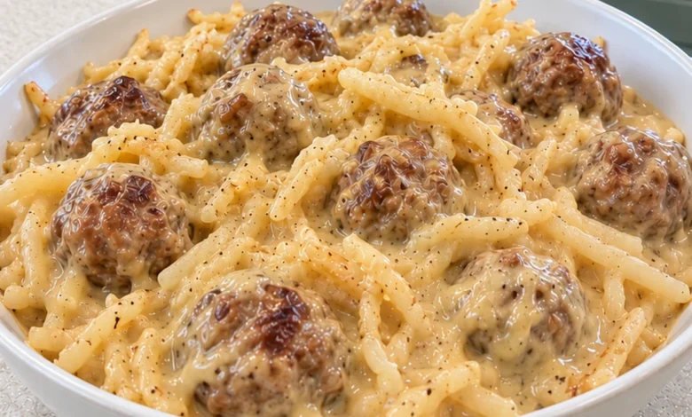 A generous serving of cheesy ranch shredded hash browns and meatballs in a thick creamy golden cheese sauce in a white bowl